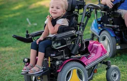 Kind im Reha-Buggy bei der Beratung