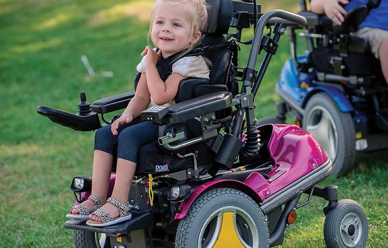 Kind im Reha-Buggy bei der Beratung