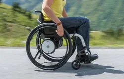 Sportlicher Rollstuhl in Bewegung vor Bergkulisse