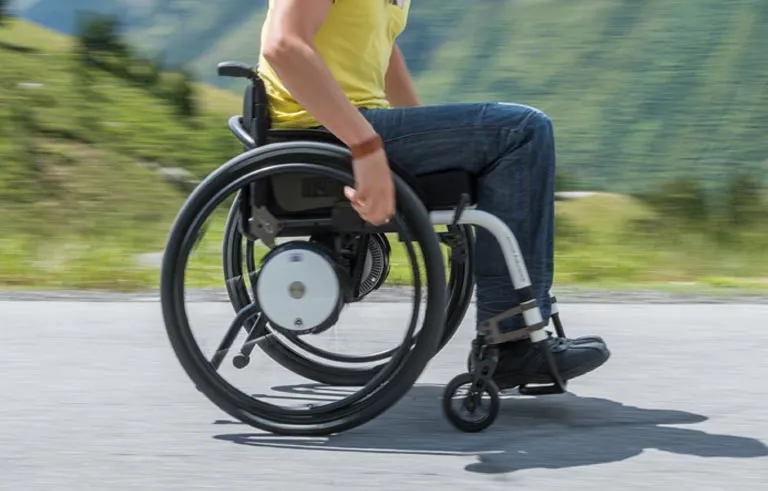 Sportlicher Rollstuhl in Bewegung vor Bergkulisse